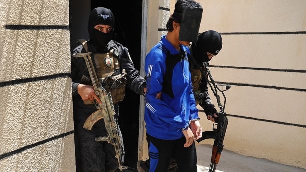 FILE - In this file picture taken on Friday, July 21, 2017, Kurdish soldiers from the Anti-Terrorism Units, carry a blindfolded an Indonesian man suspected of Islamic State membership, at a security center, in Kobani, Syria. Western governments have tacitly handed down guidance to the forces uprooting the remnants of Islamic State in Raqqa and beyond on how to handle their citizens who joined the extremist group by the thousands. (AP Photo/Hussein Malla, File)