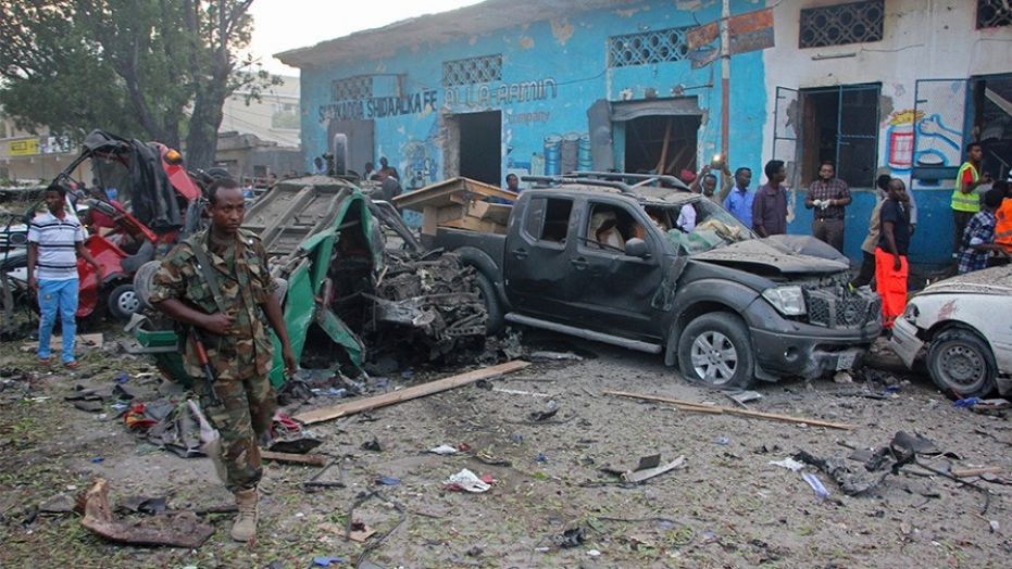 Somali soldier walk near wreckage of vehicles after a car bomb was detonated in Mogadishu, Somalia, Saturday.
