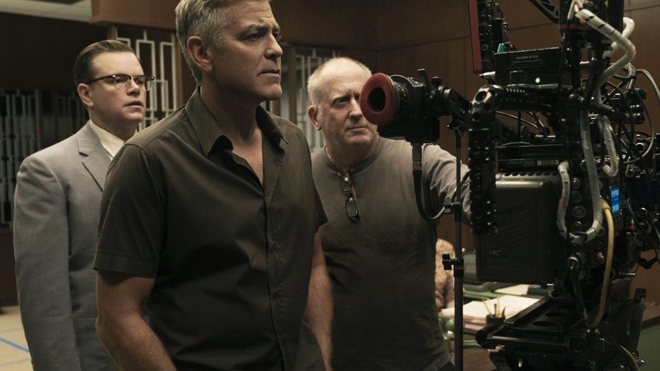Matt Damon, left, poses next to George Clooney, center, on the set of "Suburbicon." 
