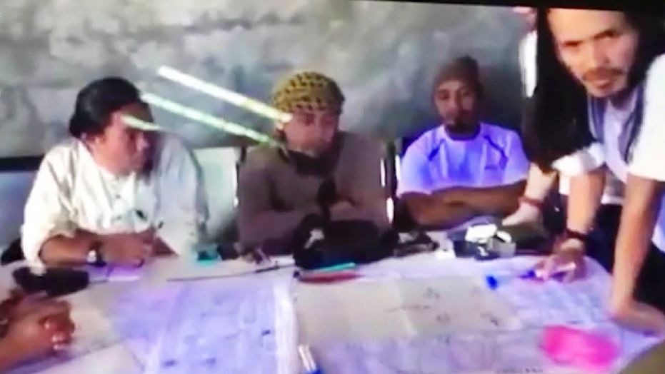 FILE - This file image taken from undated video shown to The Associated Press by the Philippine military shows the purported leader of the Islamic State group Southeast Asia branch, Isnilon Hapilon, center, at a meeting of militants at an undisclosed location.