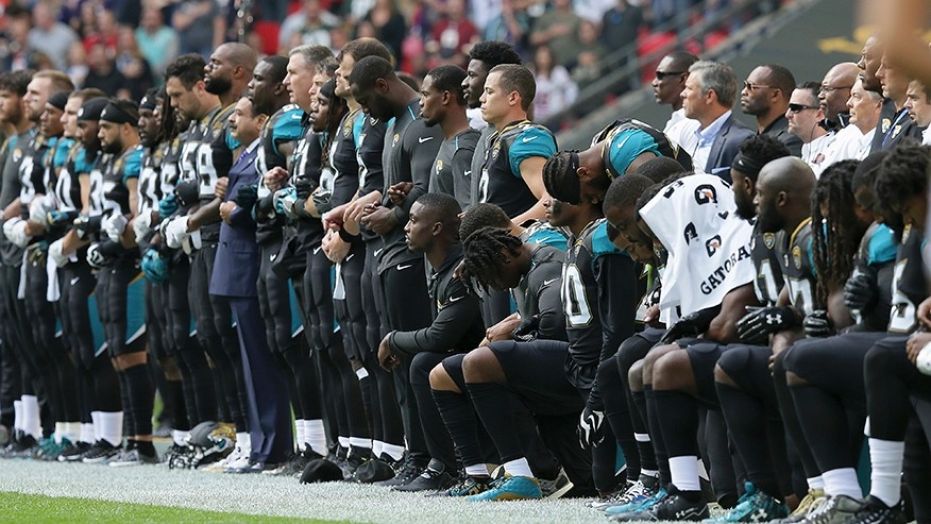 FILE - In this Sept. 24, 2017, file photo, Jacksonville Jaguars NFL football players are shown, some standing an some kneeling, during the playing of the national anthem before an NFL football game against the Baltimore Ravens at Wembley Stadium in London.
