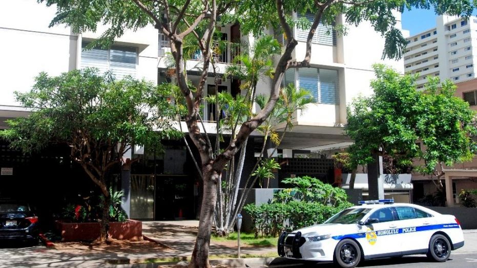A Honolulu police patrol car is parked outside an apartment building where human remains were found in the city's Waikiki neighborhood, April 12, 2017.