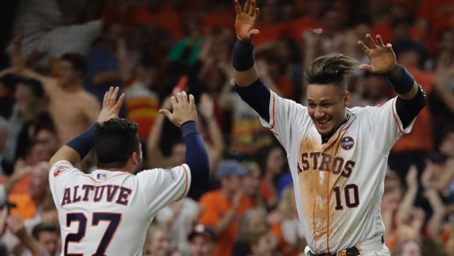 Houston Astros' Yuli Gurriel is congratulated by Jose Altuve after scoring during the fifth inning of Game 7 of baseball's American League Championship Series against the New York Yankees Saturday, Oct. 21, 2017, in Houston. 