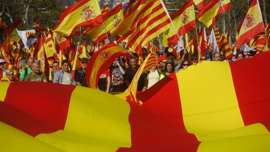 Nationalist activists protest with Spanish and Catalan flags during a mass rally against Catalonia's declaration of independence in Barcelona, Spain, Sunday, Oct. 29, 2017.