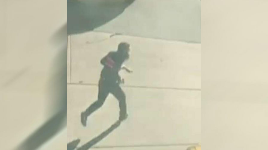 Eyewitness records video of suspect running through traffic, brandishing what appear to be handguns.