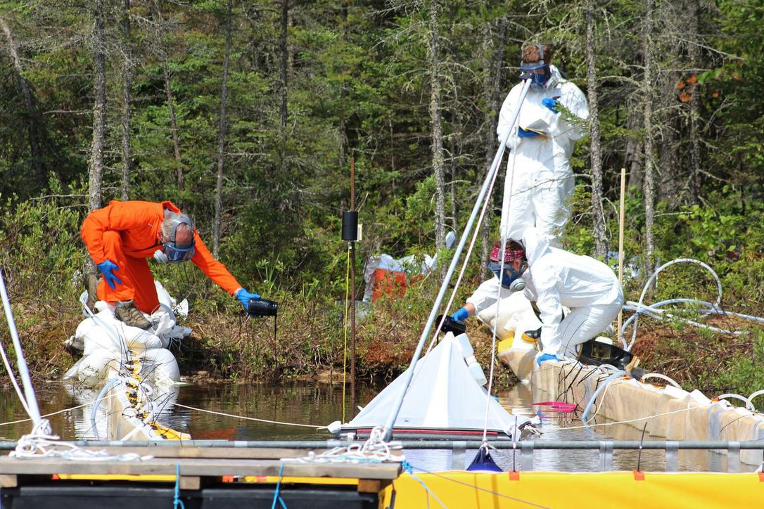 Researchers and professional spill responders, in this undated photo, monitor a deliberate spill of oilsands bitumen and crude oil into a lake in northwestern Ontario in an experiment over how the ecosystem responds. The pilot project, known as Freshwater Oil Spill Remediation Study, is being done at the International Institute for Sustainable Development Experimental Lakes Area, southeast of Kenora, Ont.