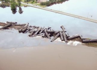 Train from Alberta derails in Iowa, leaking crude oil into floodwaters from rain-swollen river (Report)