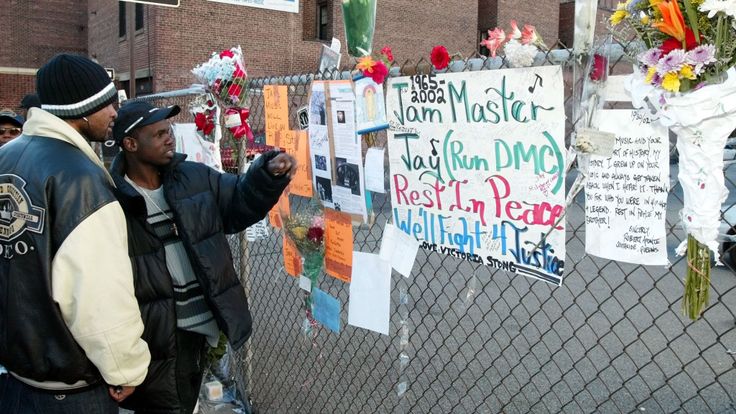 Olel Right (L) and Lionel Frazer (R) look at a wall of flowers and cards outside a music studio in Queens, New York 31 October, 2002 where former Run DMC member Jason Mizell, who was also known as DJ Jam Master Jay, was shot and killed late 30 October. There was no immediate word on the motive for the shooting of Jam Master Jay who was in his studio in New York&#39;s Queens neighborhood with another man. The other unidentified man suffers from a wound in the arm. AFP PHOTO/Mat